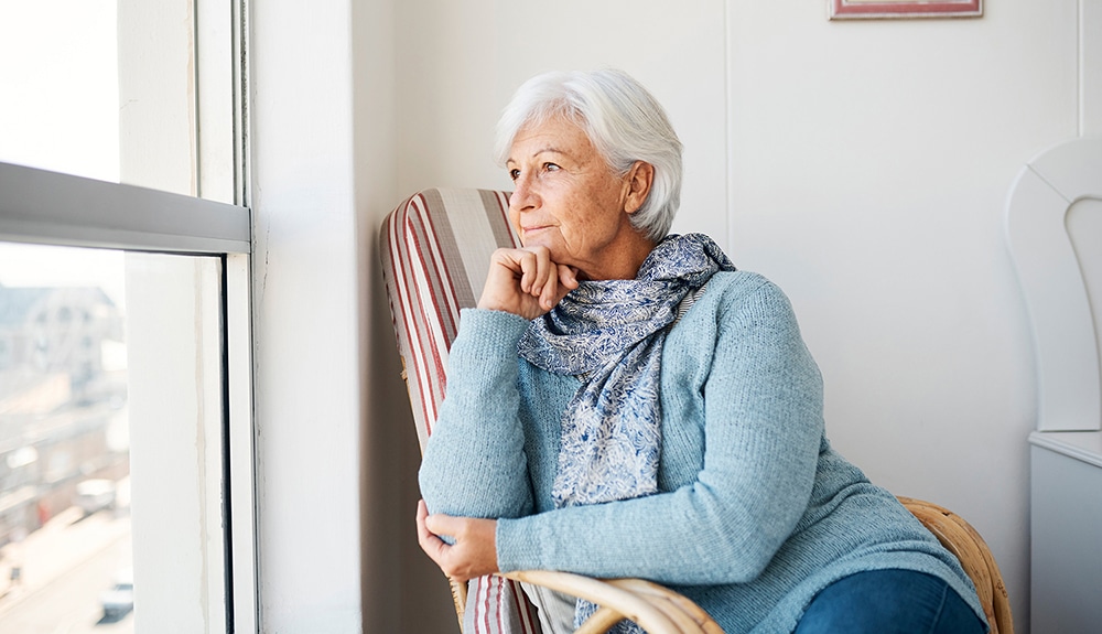 Older woman gazing out of a window