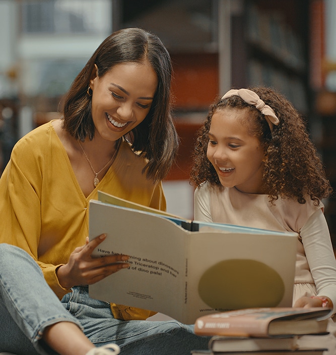 Woman and girl reading a book together