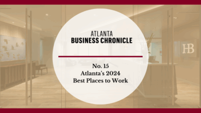 A graphic with Atlanta Business Chronicle and No. 15 Atlantas 2024 Best Places to Work in bold text over a blurred office lobby background with a red border.