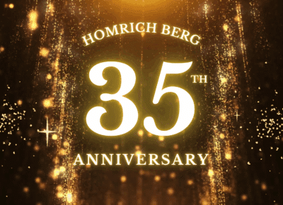 Glowing gold text reads “Homrich Berg 35th Anniversary” against a sparkling, festive golden background with falling glitter and light effects.